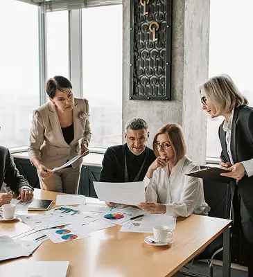 Financial analysts dissecting data for clients at a conference table.