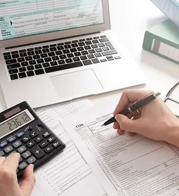 SL Capital financial expert going over data on the latest investment strategies with a calculator and spreadsheet.